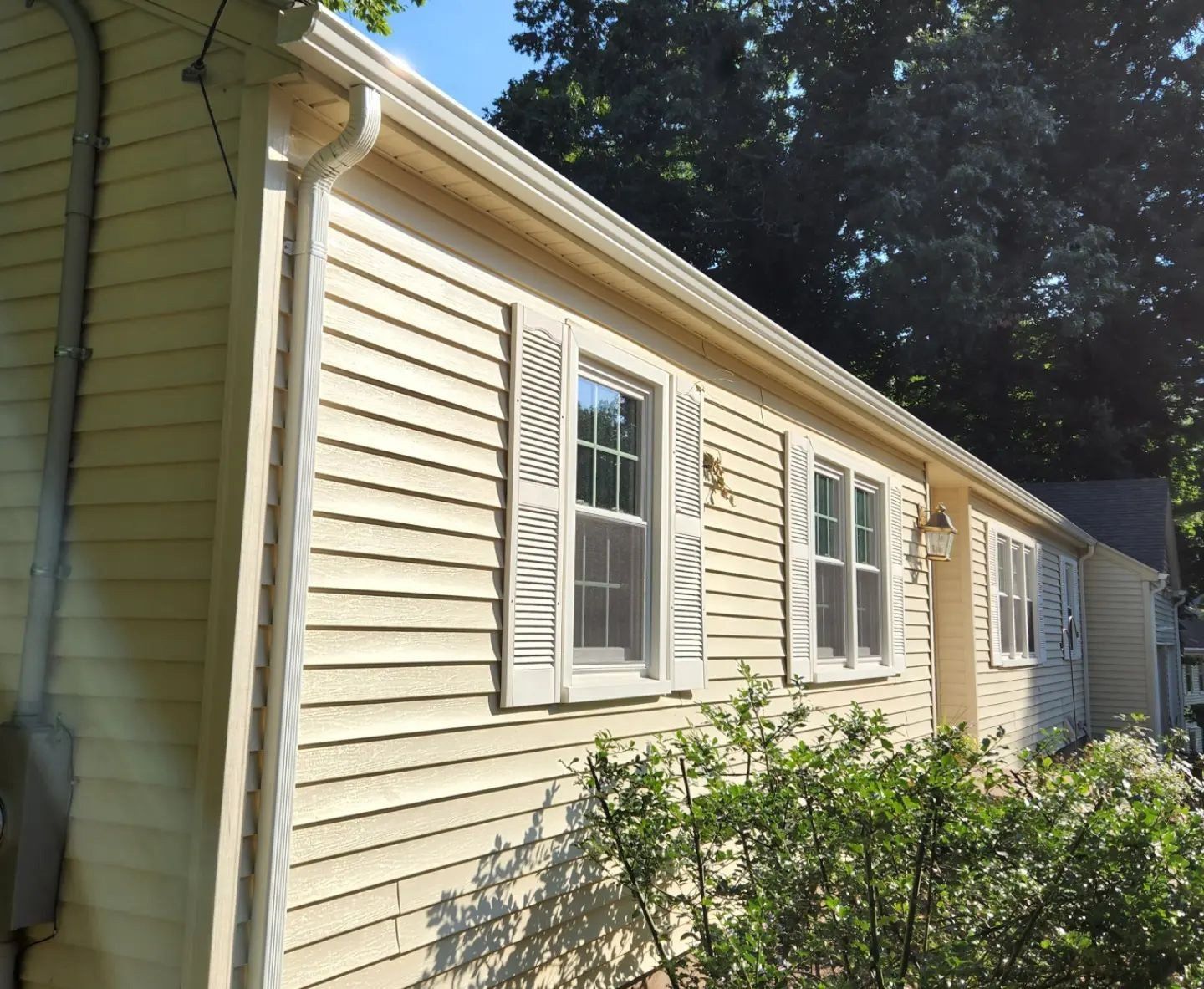 A white house with a lot of windows and shutters