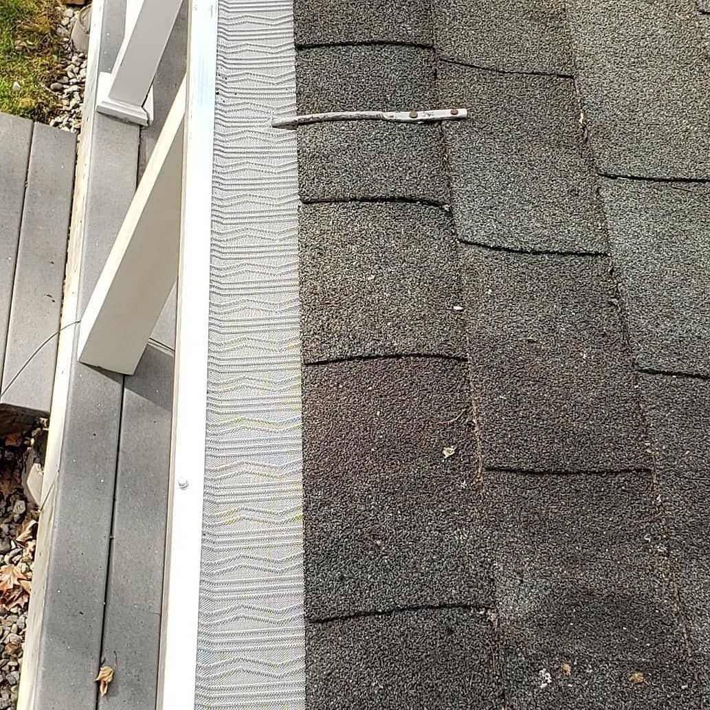 A close up of a roof with shingles and a gutter.