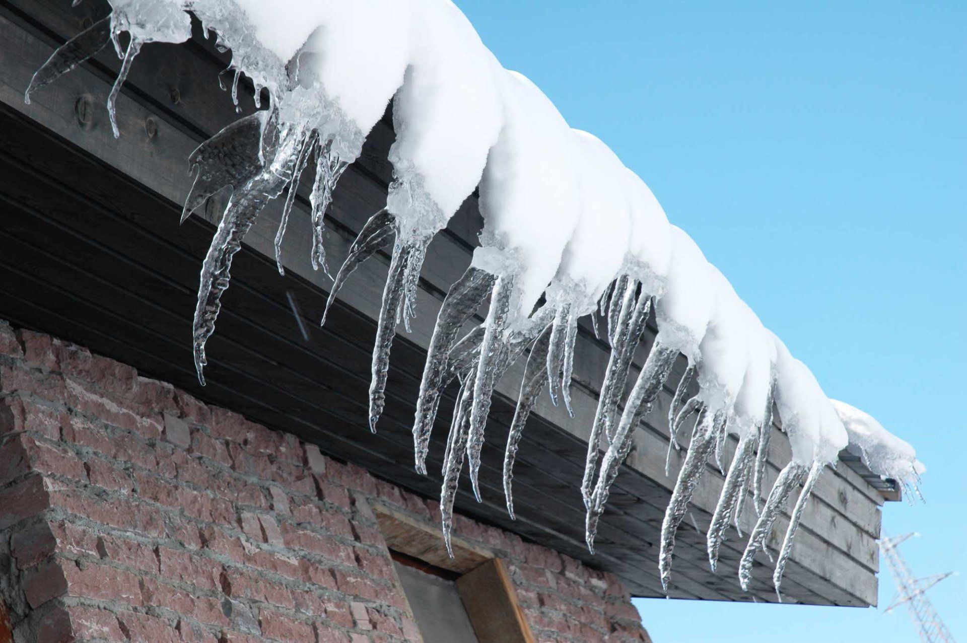 Icicles are hanging from the roof of a building