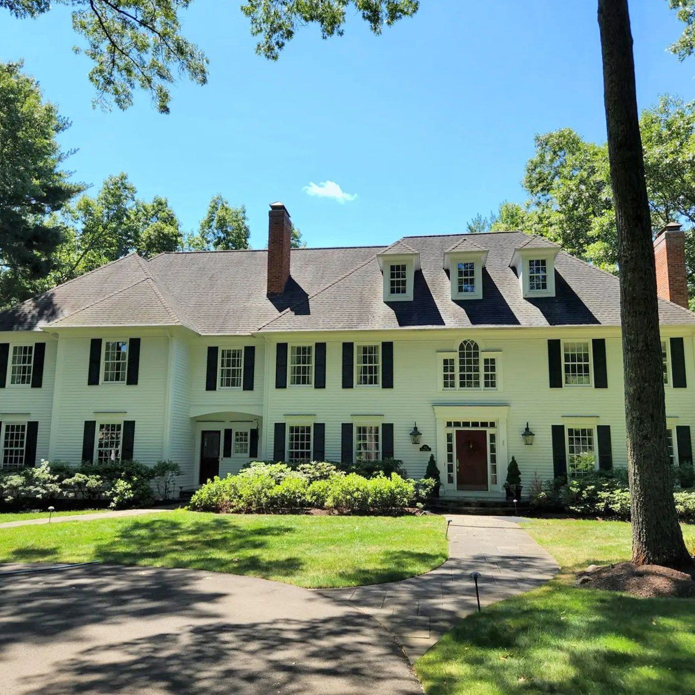 A large white house with black shutters on the windows