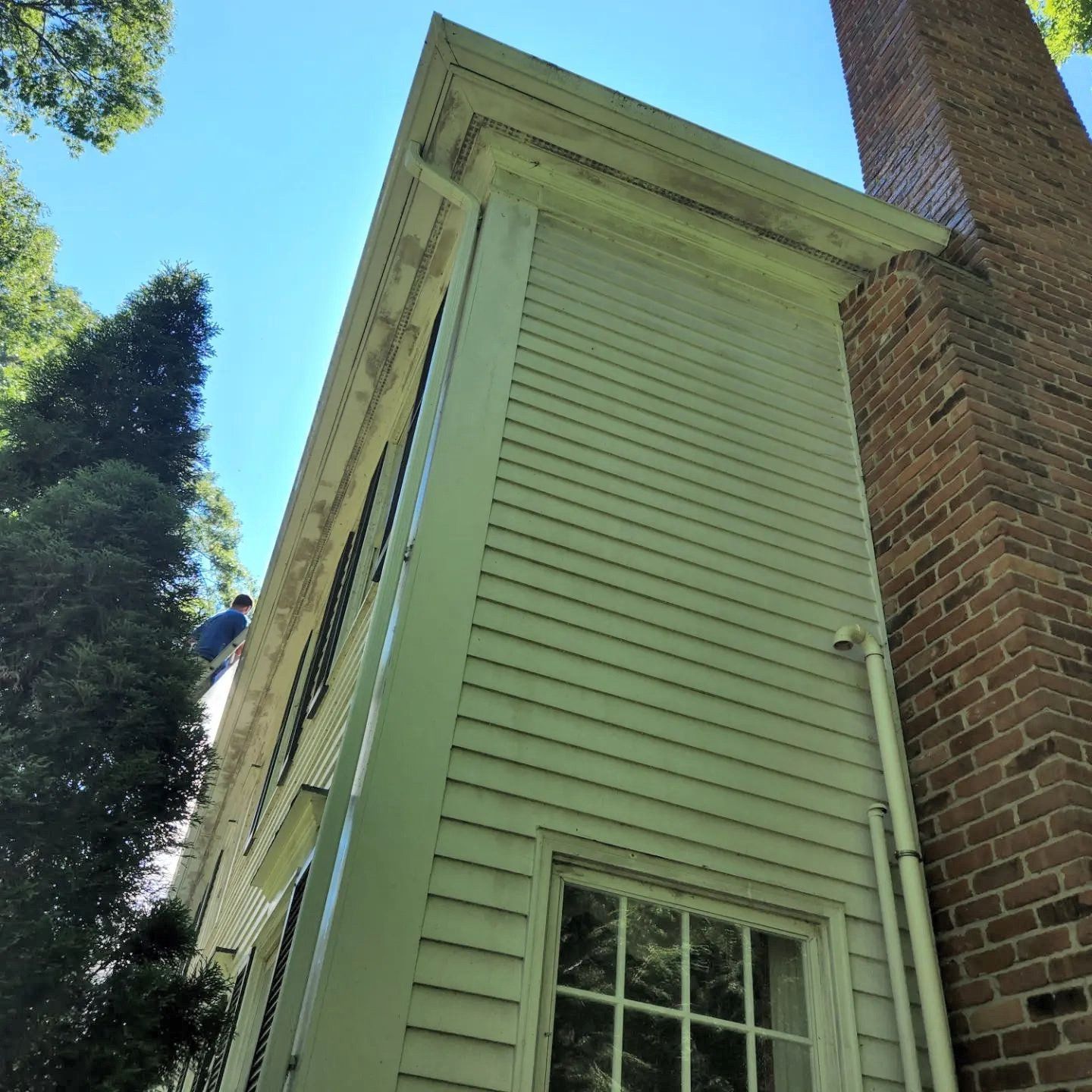 A white house with a brick chimney on the side