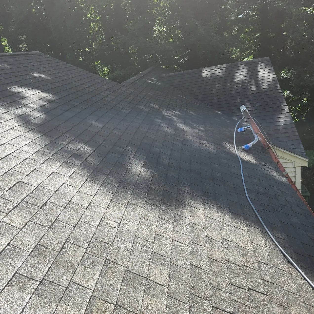 A ladder is attached to the roof of a house.