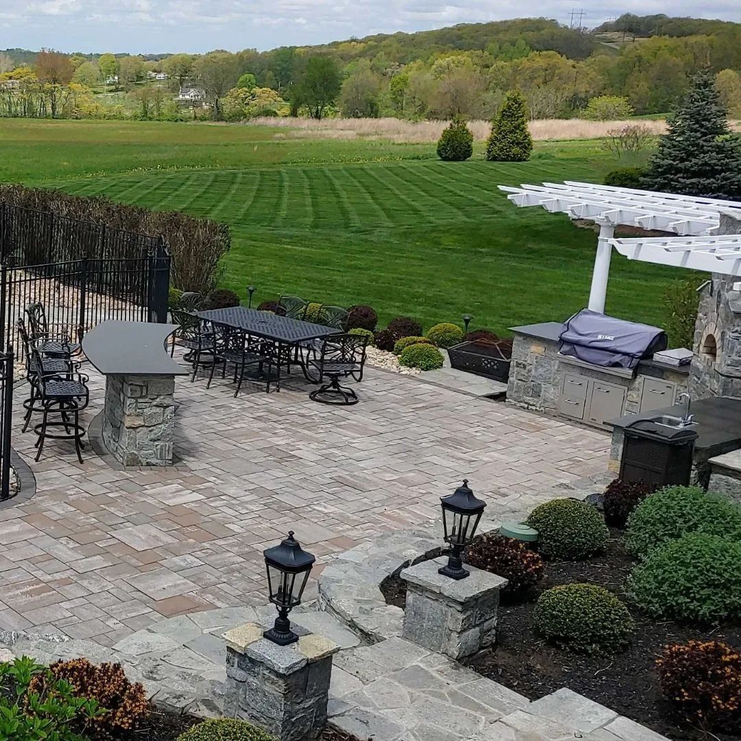 A patio with a table and chairs and a grill