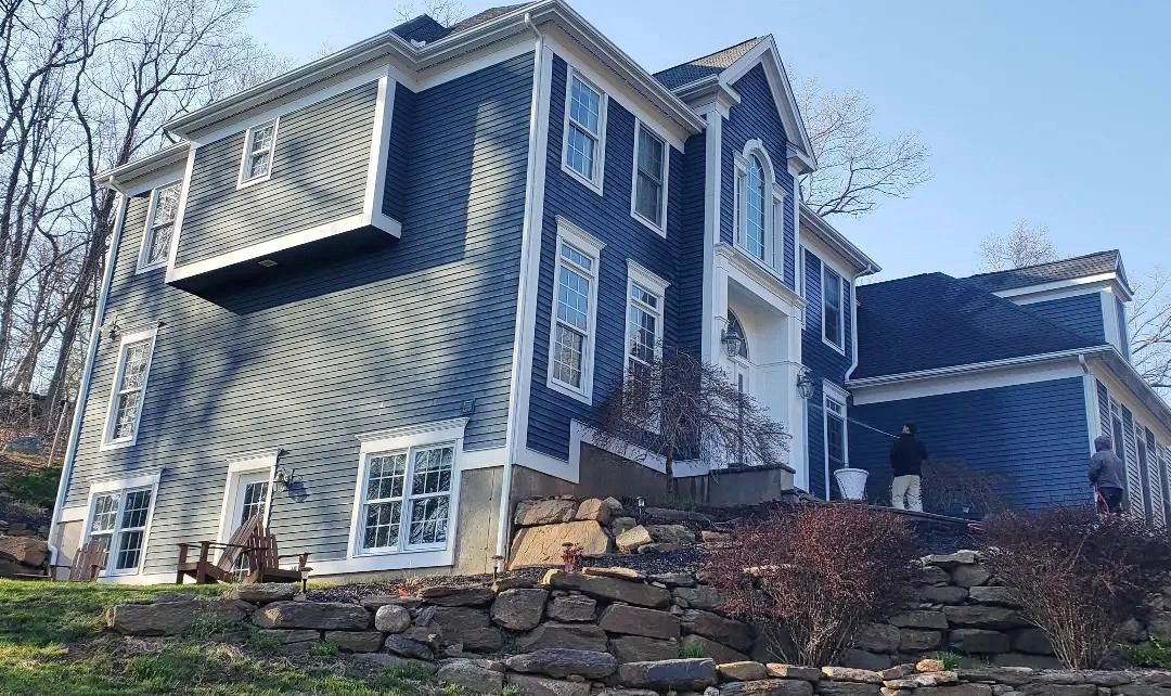 A large house with a lot of windows is sitting on top of a hill.