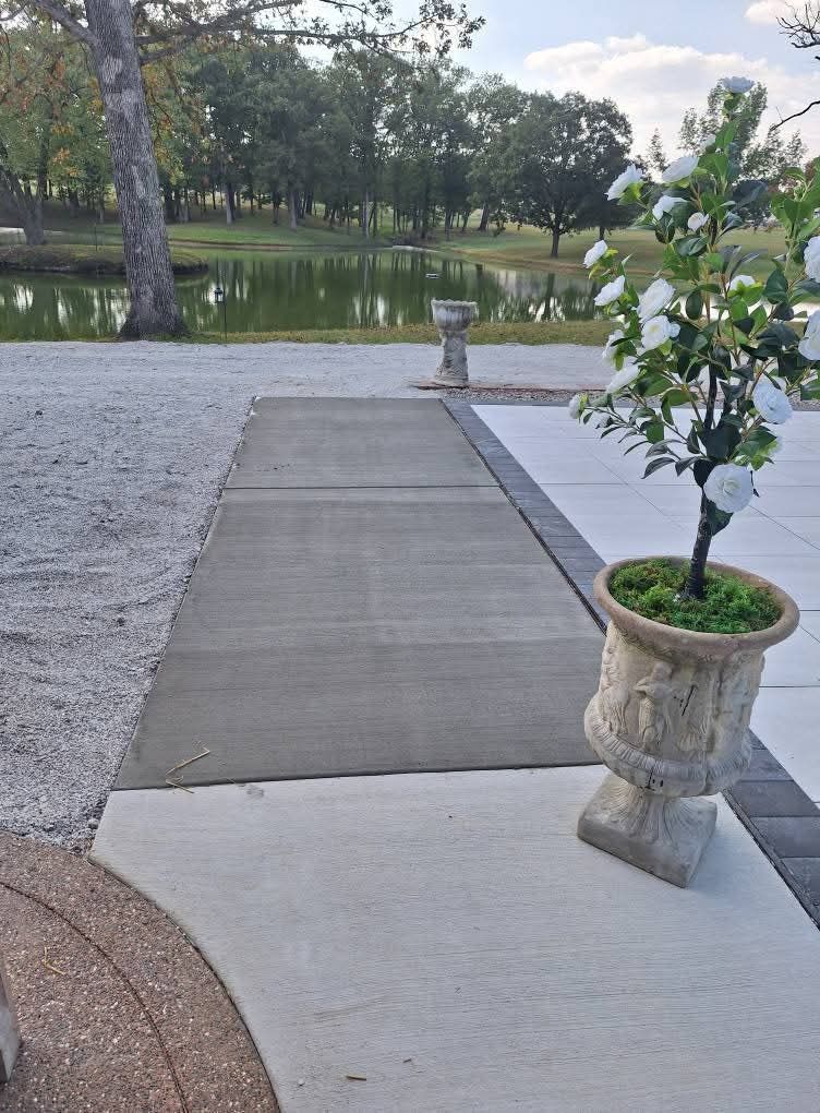 Garden walkway to a pond with a potted plant in the foreground