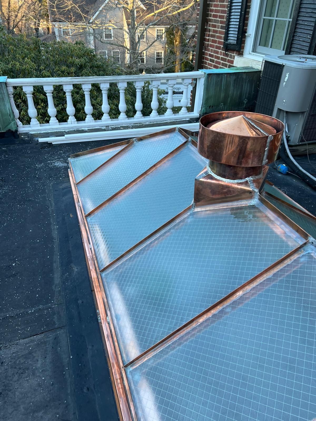 A copper roof with a chimney on top of it.