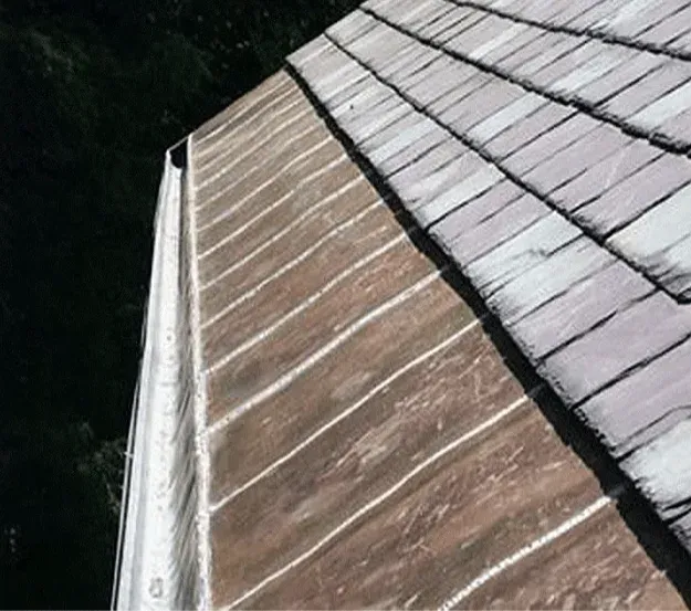 A close up of a roof with shingles and a gutter.