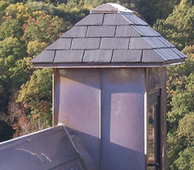 A chimney on top of a building with a slate roof