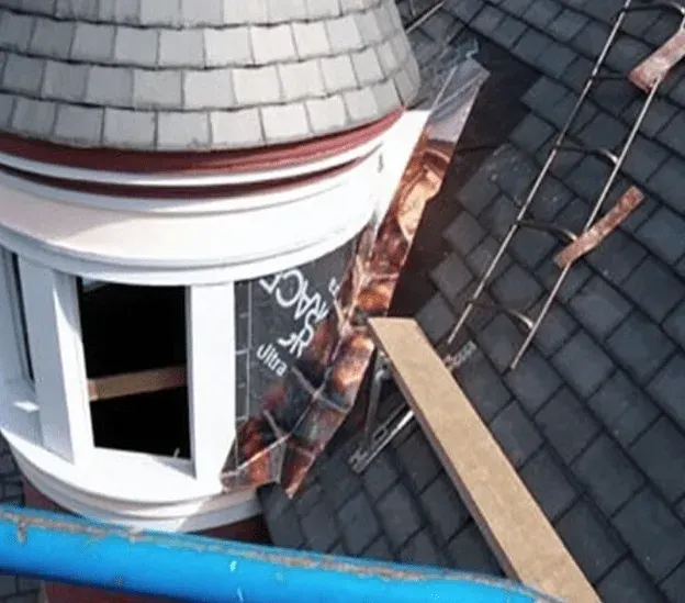 An aerial view of a roof with a window and a ladder
