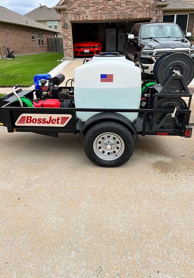 A trailer with a hose attached to it is parked in front of a house.