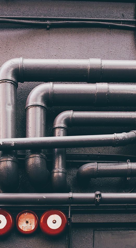 A bunch of pipes are connected to each other on a wall.