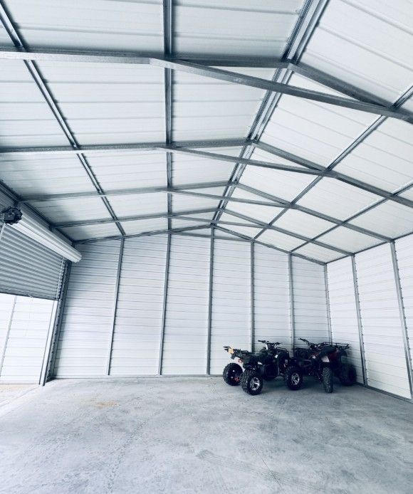Three atvs are parked inside of a metal building