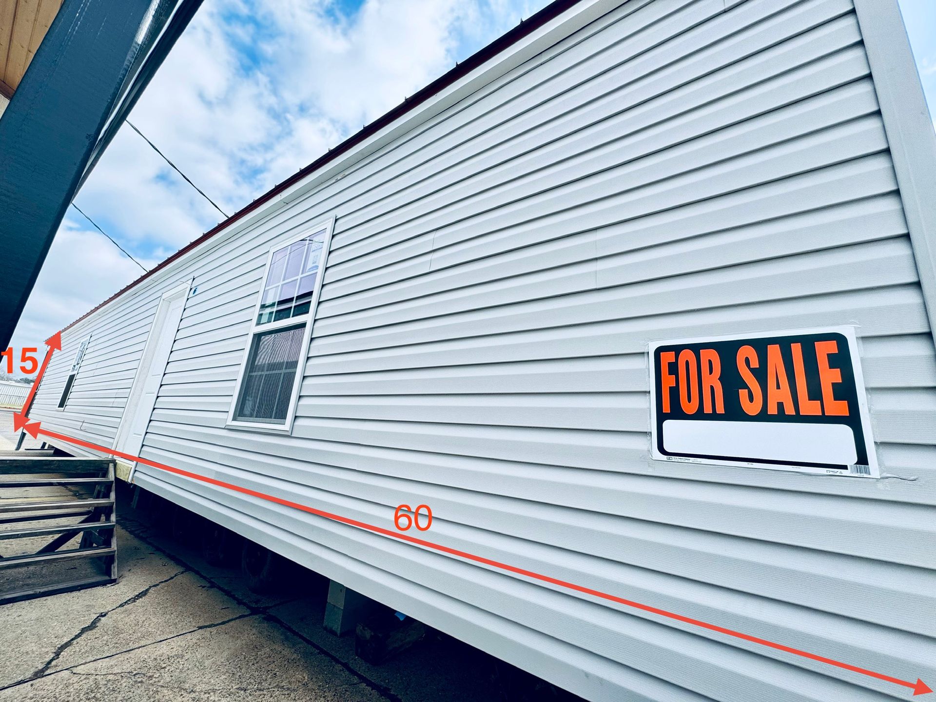 A mobile home with a for sale sign on the side of it.