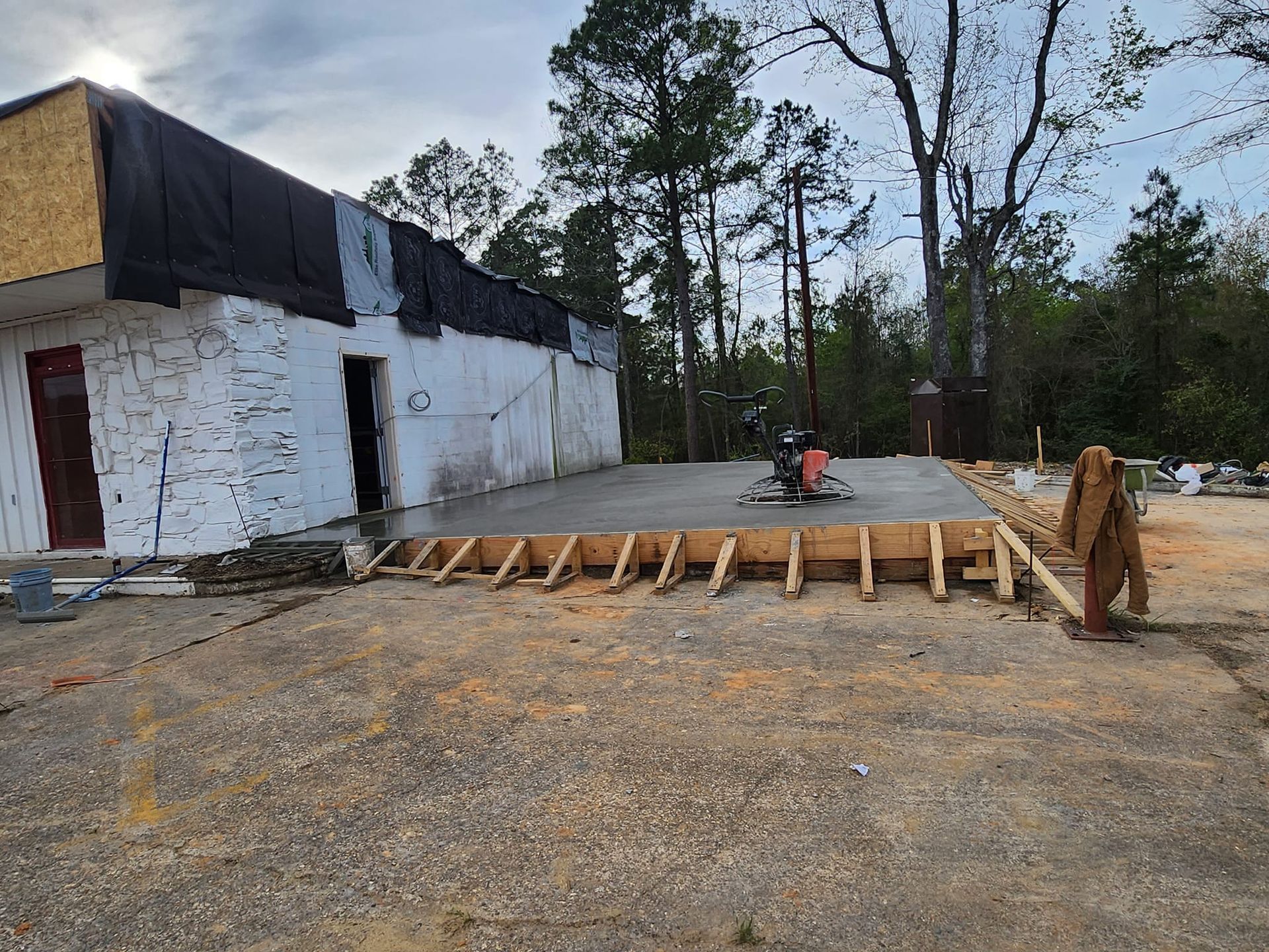 A concrete driveway is being built in front of a building.