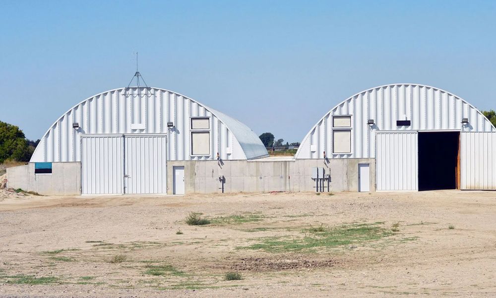 A large metal building with a covered porch in front of it.