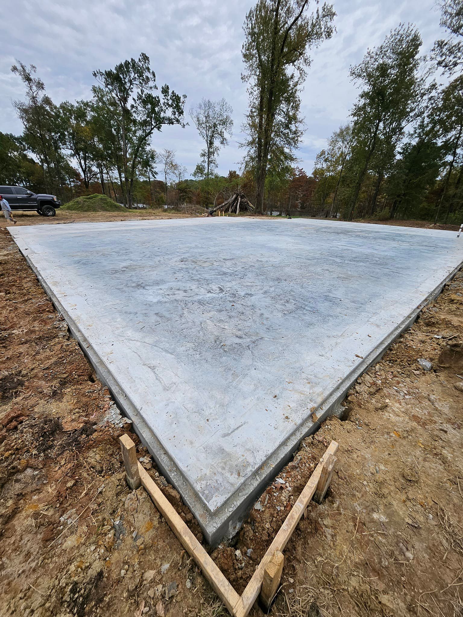 A large concrete slab is sitting in the middle of a dirt field.