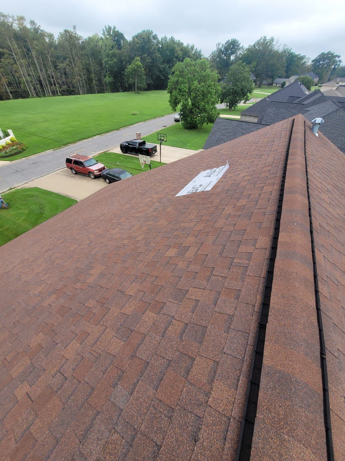 An aerial view of a roof of a house in a residential area.