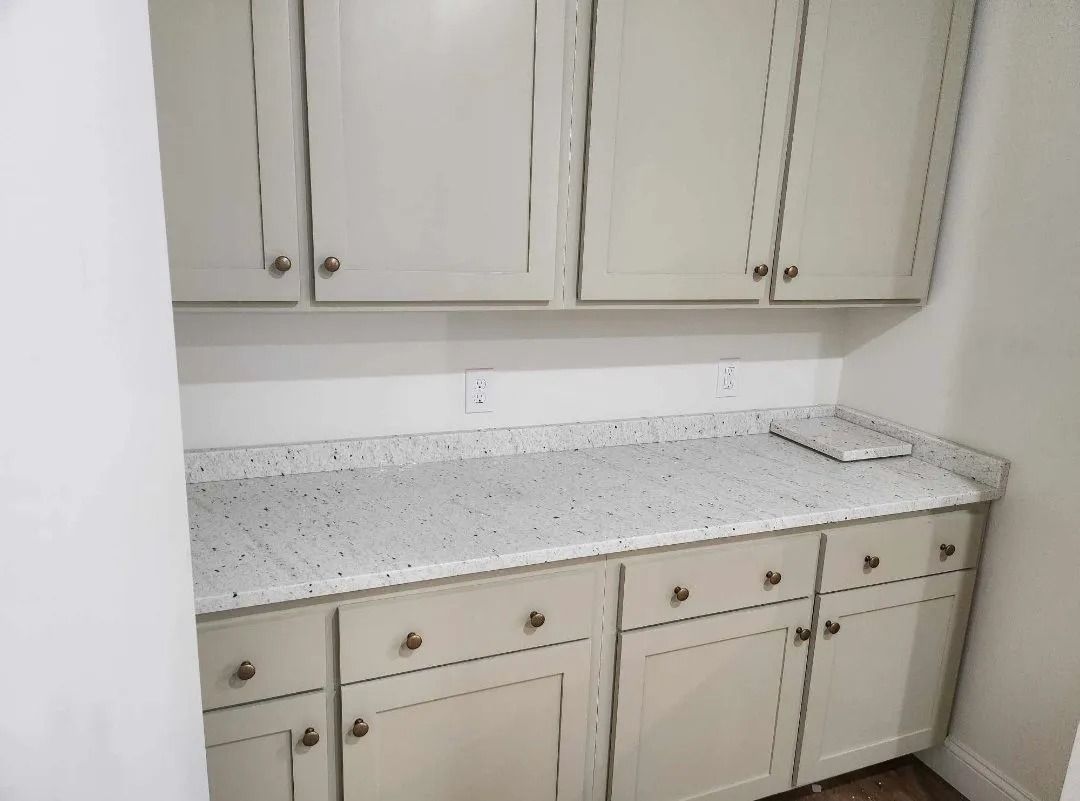 Kitchen pantry with light-colored cabinets, countertop, and hardware.