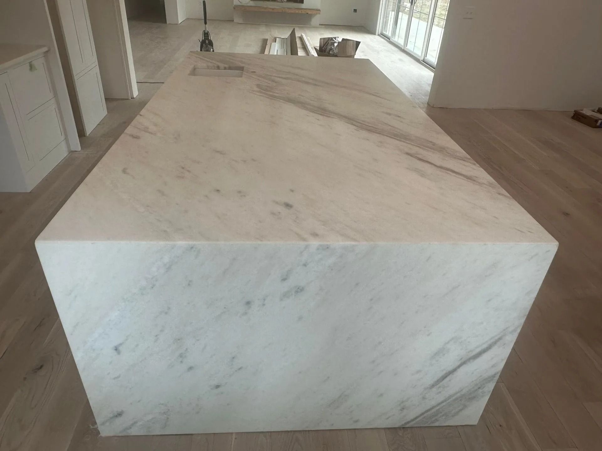 Large white marble kitchen island with light veining.
