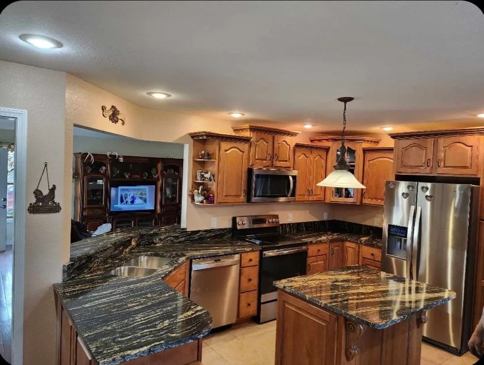 Kitchen with wooden cabinets, granite countertops, and stainless steel appliances.