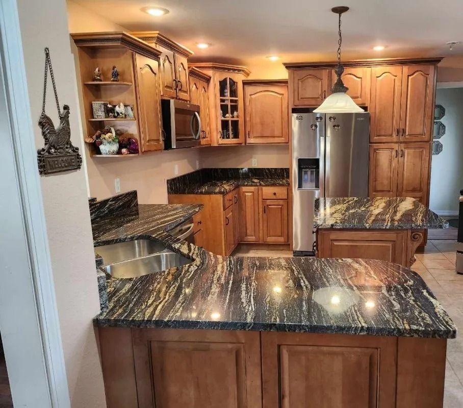 Kitchen with wooden cabinets and granite countertops, stainless steel appliances, and island.