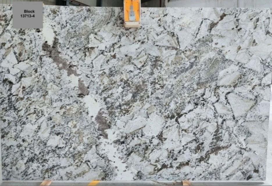 Large slab of granite with a light background and dark, irregular patterns.