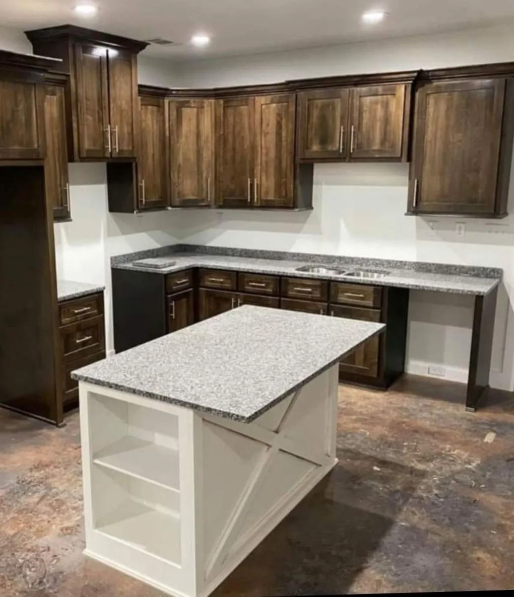 Kitchen with brown cabinets, white island, and gray countertops.