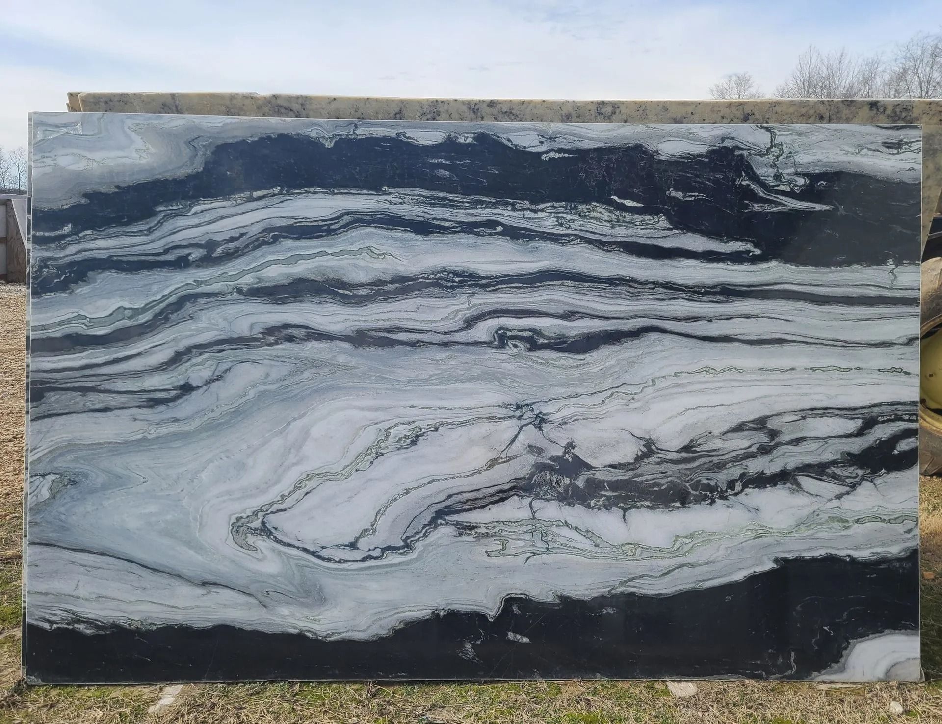 Large slab of black and white marble with wavy, layered patterns.