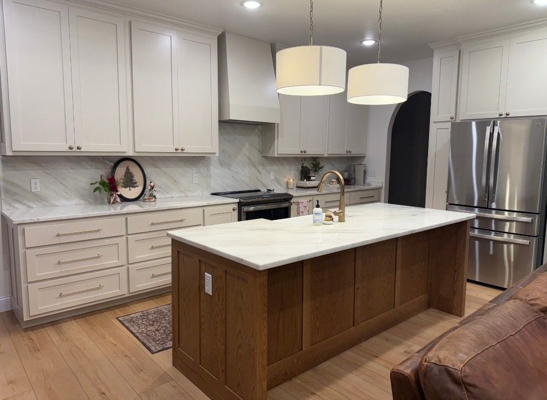 A kitchen with white cabinets, a wooden island, and stainless steel appliances.