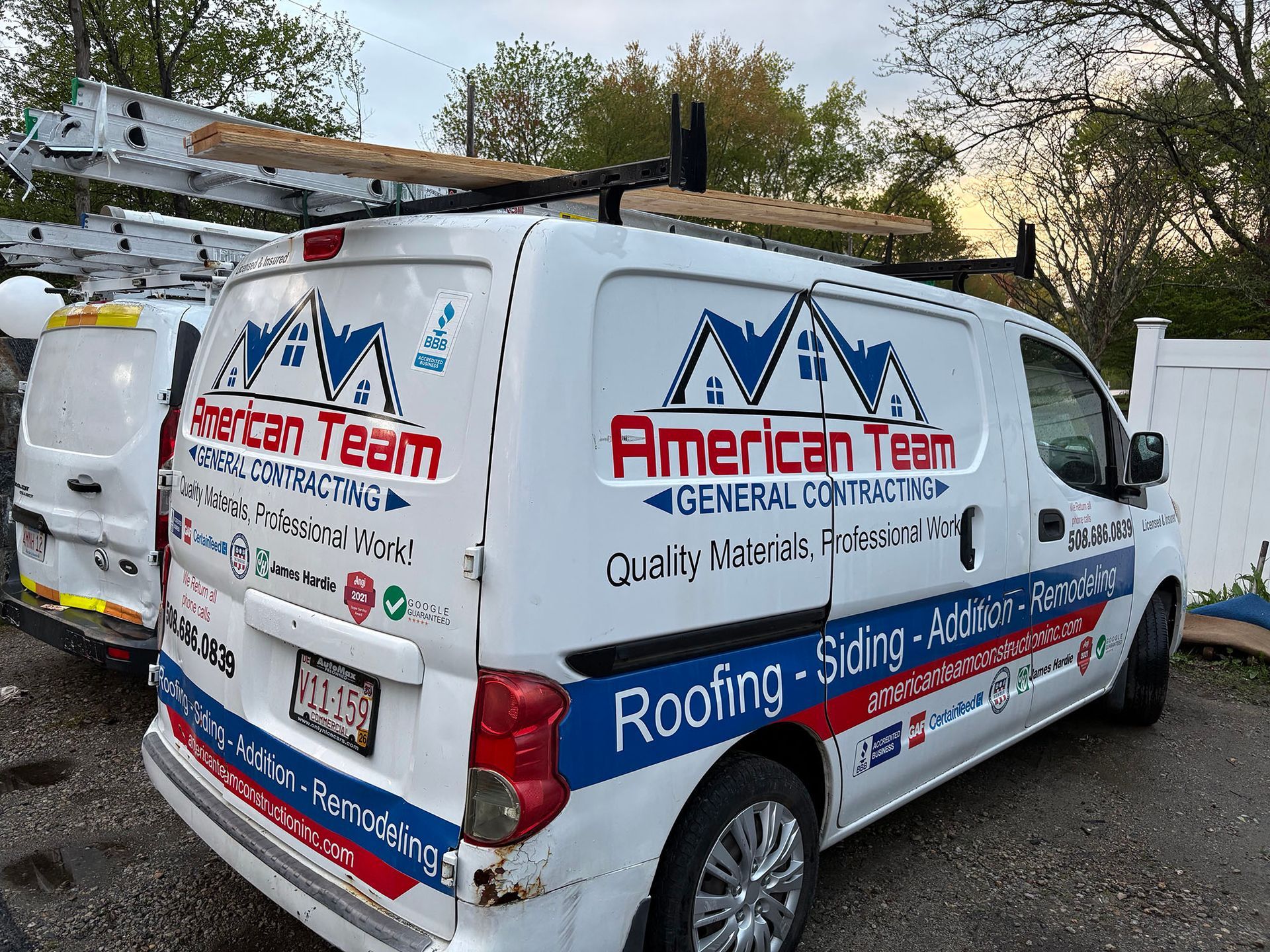 White American Team service van with roof rack and company branding parked outdoors