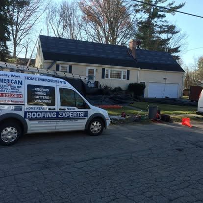 Roofing service van parked by a house with workers and tools during roof repair.