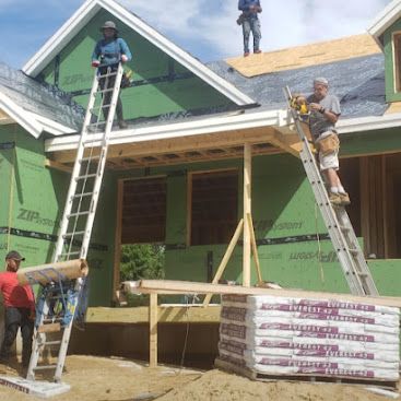 Workers on ladders and roof repairing a green house with exposed framing and shingles.