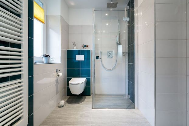 Modern bathroom with walk-in shower, toilet, and white tile walls