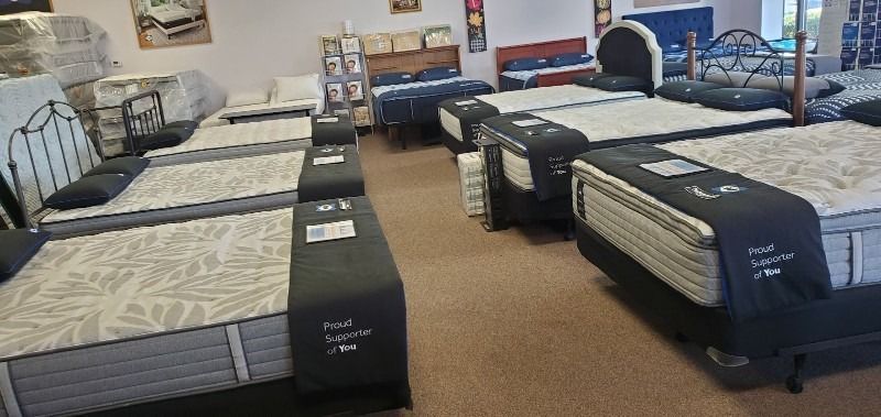 A mattress store filled with lots of mattresses and beds.