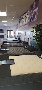 A mattress store with a lot of mattresses on display.