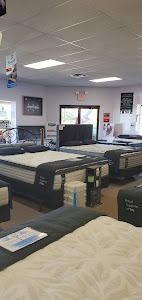 A mattress store filled with lots of beds and mattresses.
