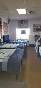 A room filled with lots of beds and mattresses in a store.