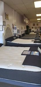 A mattress store filled with lots of mattresses and beds.