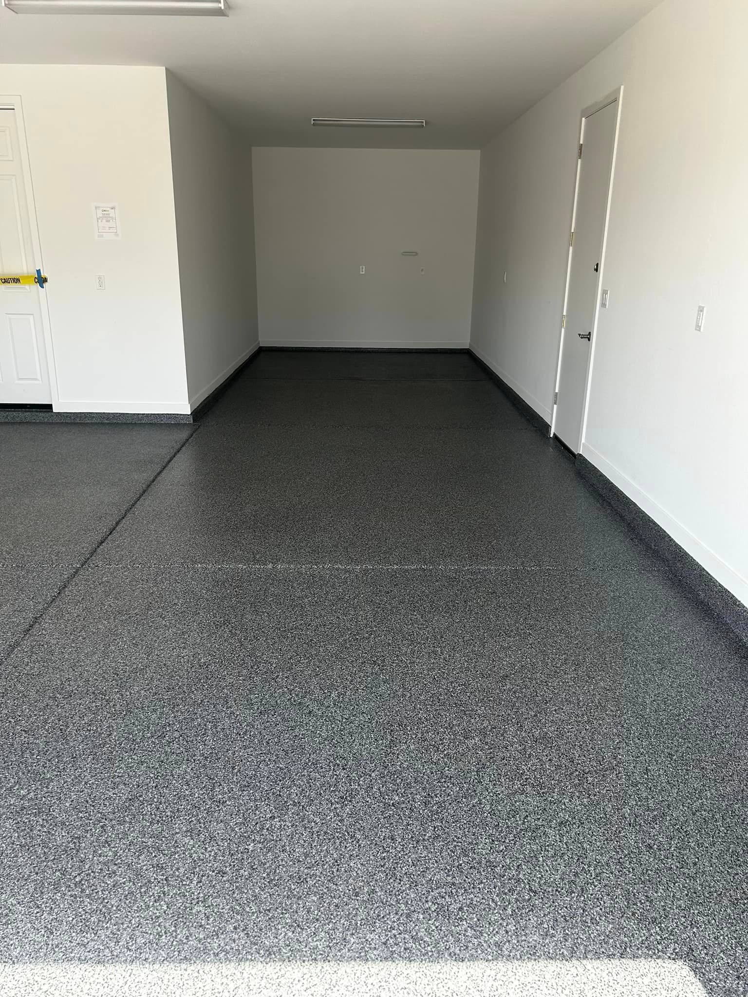 A garage with a black and white floor and white walls.