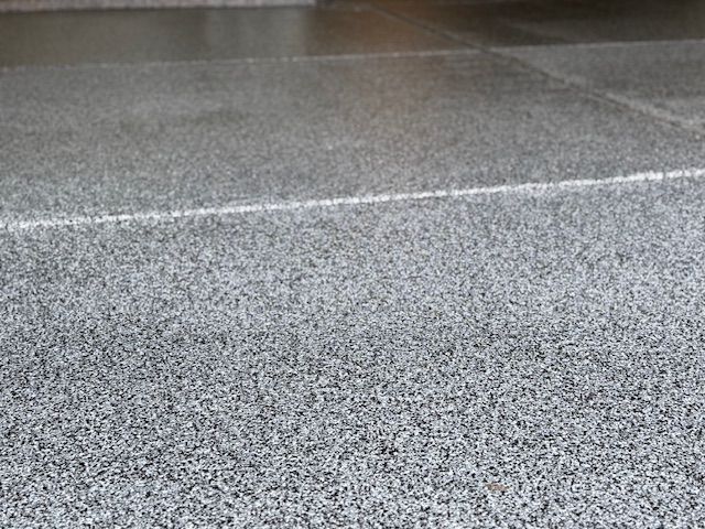 A close up of a gray tile floor with a white line on it.