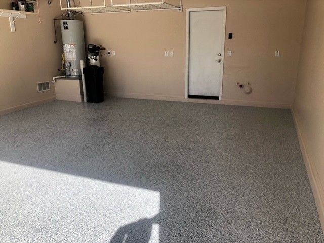 An empty garage with a water heater and a door.