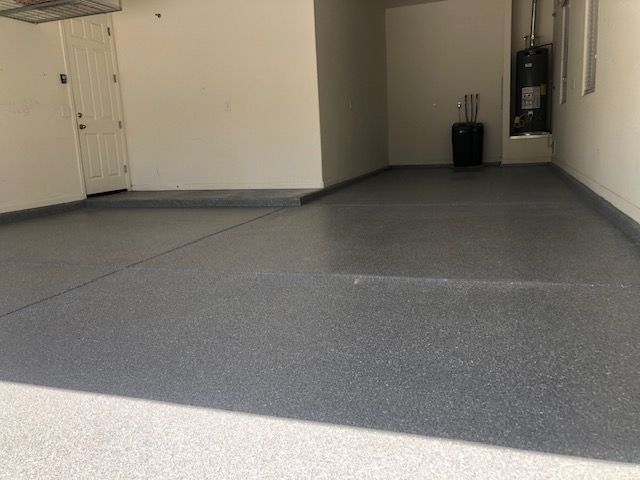 A garage with a gray floor and white walls.