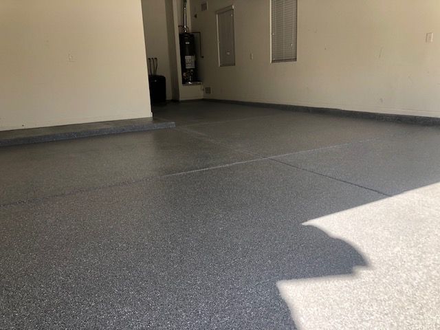 A garage with a gray floor and white walls.
