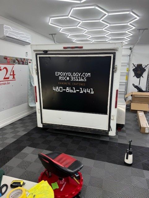 A white trailer with a black sign that says epoxyology.com
