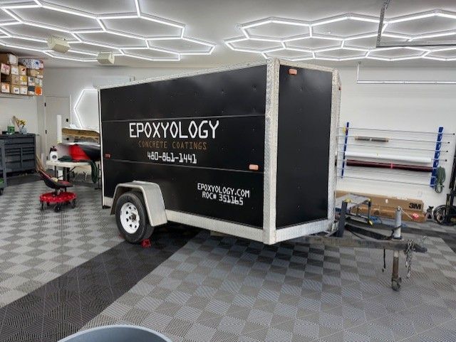 A black and white trailer is parked in a garage.