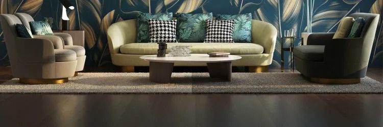 Living room with green sofa, two armchairs, and coffee table on a rug against a floral wallpaper backdrop.