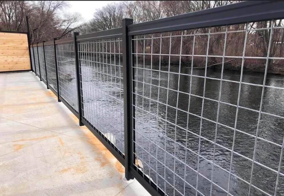 A bridge over a river with a fence surrounding it.