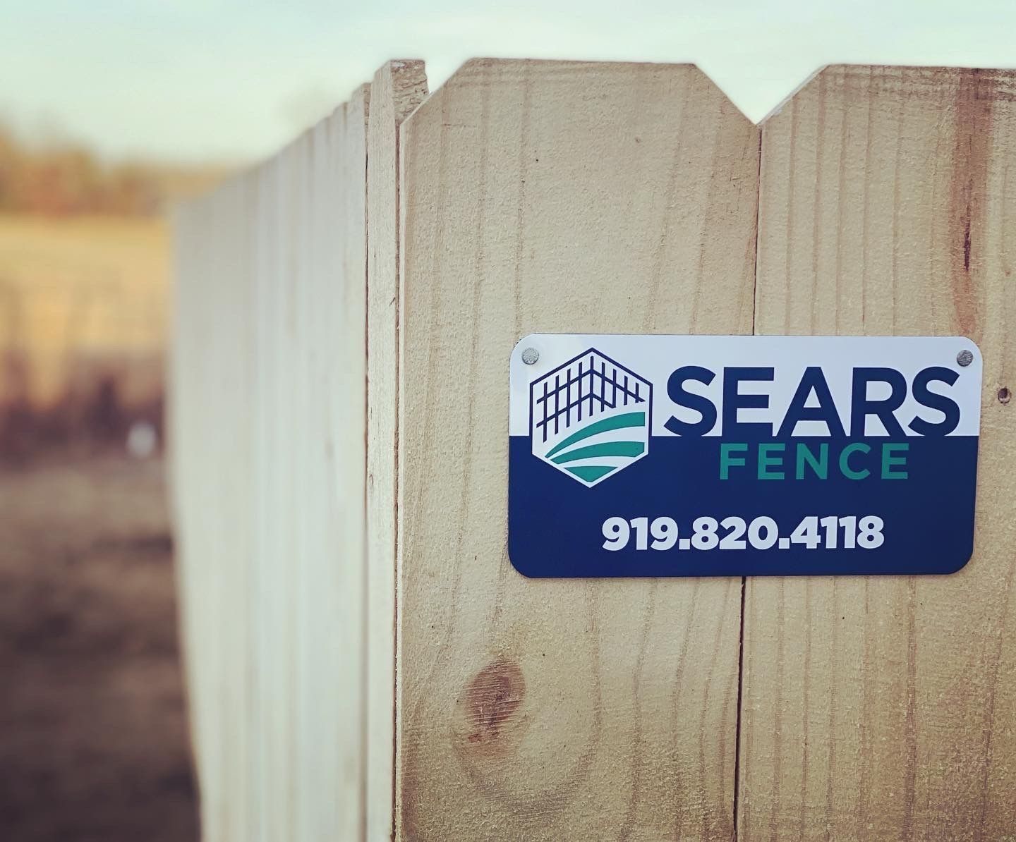 A sears fence sign on a wooden fence