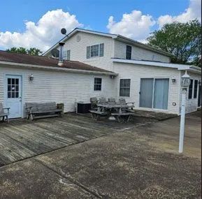 a white house with a picnic table and benches in front of it