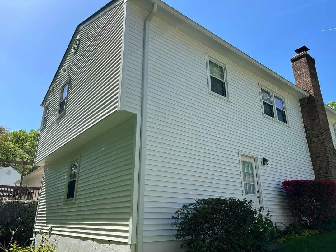 a white house with a chimney on the side of it